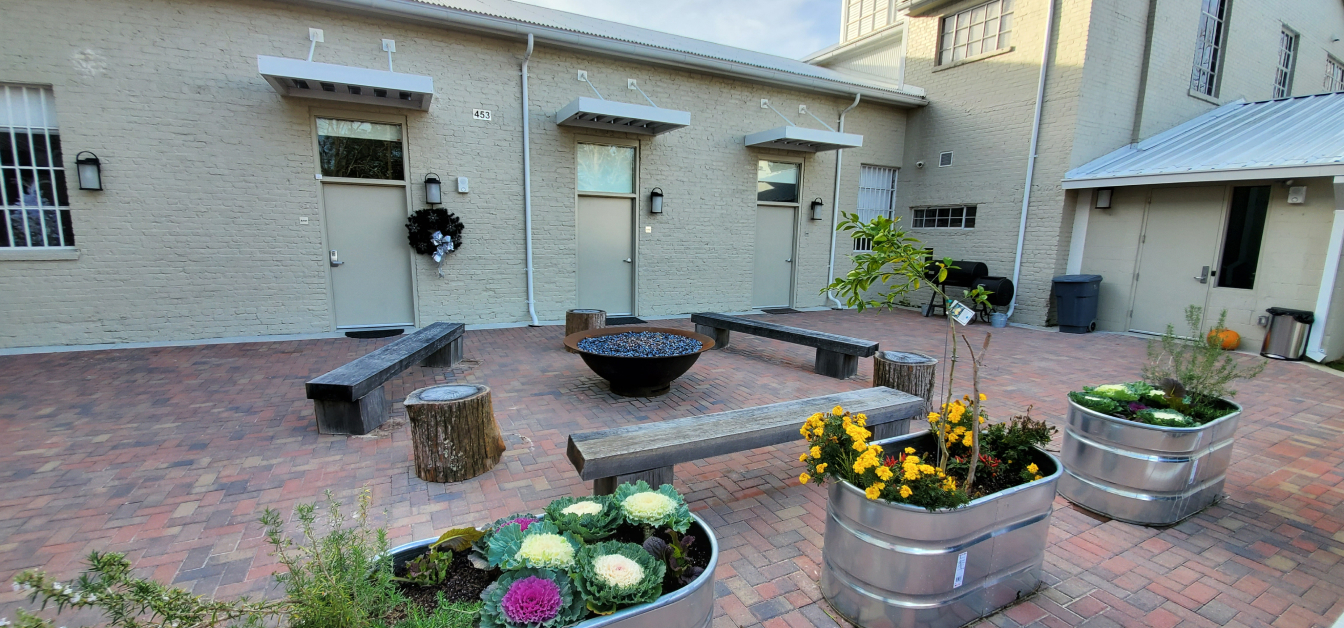 courtyard with benches, fire pit, potted plants