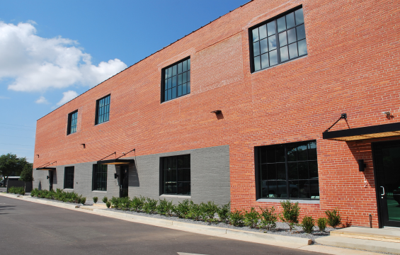 renovated brick building with paved parking lot