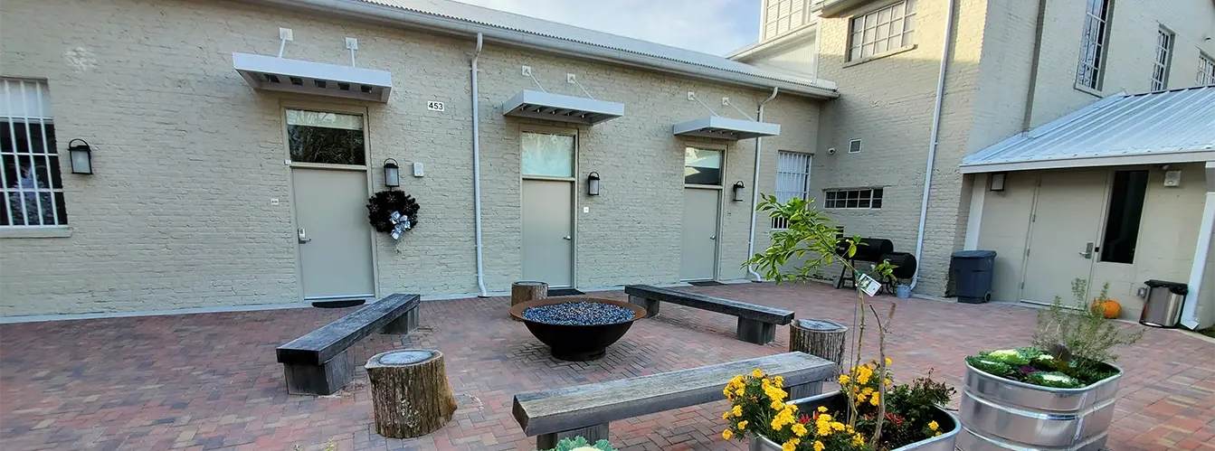 brick patio with benches and flowers and fire pit